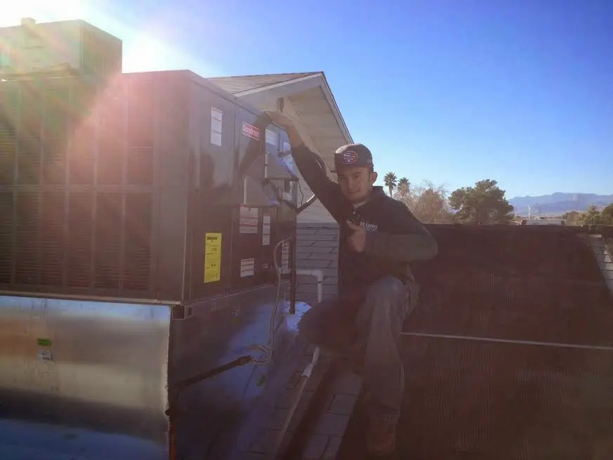 HVAC technician performing AC Tune-Up on a rooftop unit in Surprise